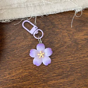 Detailed close-up of a sweet purple cherry blossom keychain, perfect stylish accessory gift.