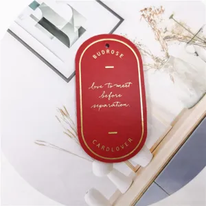 Close-up of red leather bookmark with gold foil text, minimalist page marker for reading.
