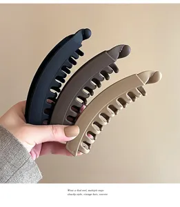Matte banana hair clip detail view, showcasing sleek vertical claw design in neutral hues.
