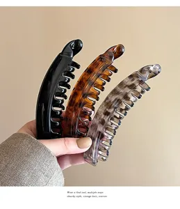 Detailed view of fashionable resin banana hair clips in black, tortoise and grey shades.