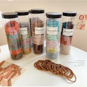 Canned colorful hair ties set in transparent jars, elastic hair bands for daily ponytail styling.