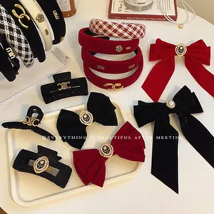 Detailed view of black and red velvet hair bows, claws and headbands with chic metal logos.