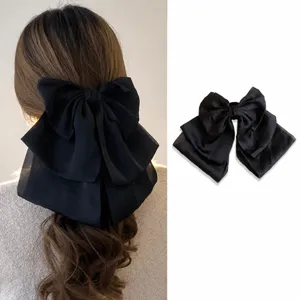 Detailed view of the elegant black velvet bow hair clip with layered ribbon design.