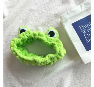 Detalle de diadema de felpa de rana verde linda, material suave para el lavado de cara diario.