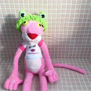 Detalle de peluche Pantera Rosa con una linda diadema de rana verde y camiseta blanca estampada.