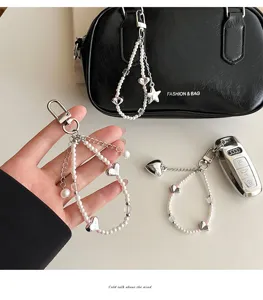 Detailed view of sweet pearl keychain with silver heart pendants, perfect for bags and keys.