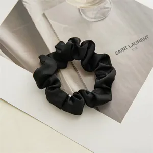 Elegant black satin hair scrunchie, smooth texture for daily styling, minimalist design.