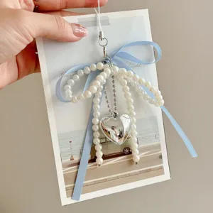 Pearl ribbon bow charm detail showing blue bow and silver heart pendant for bag and phone case
