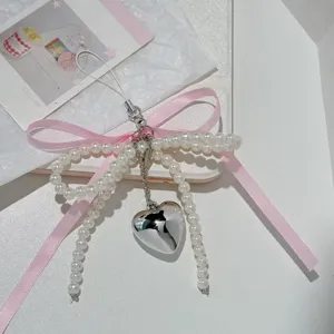 Pearl bow phone charm and bag pendant with pink ribbon and silver heart pendant detail