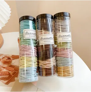 Detailed shot of colorful hair ties in transparent cylindrical containers, soft pastel tones.