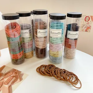 Cylindrical packaged colorful hair ties elastic rubber bands for daily styling ponytails.
