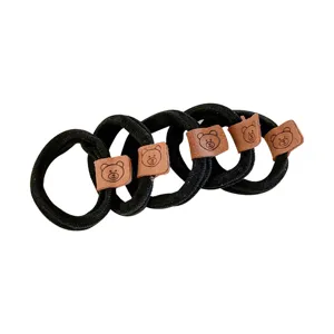 Elastici per capelli neri con toppa in pelle di orsetto per code di cavallo.