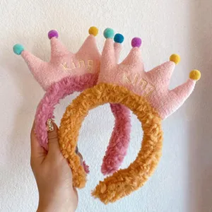 Plump plush crown headband detail showing soft texture, colorful pom poms and cute embroidery.