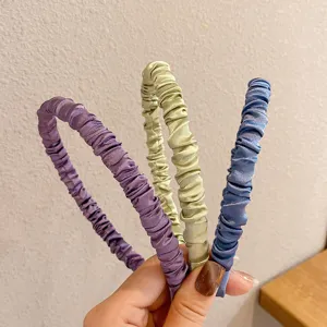 Detail view of satin pleated headbands in purple, green and blue, soft hair accessories for women.