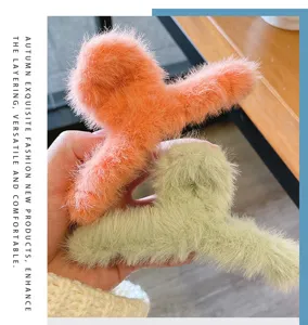Détail en gros plan de la pince à cheveux en peluche moelleuse, texture douce et couleurs automnales.