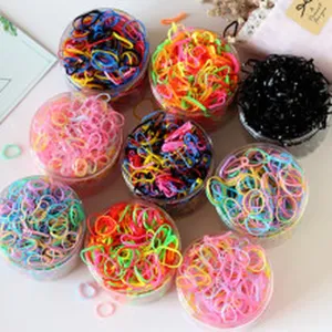 Piccoli elastici per capelli colorati in barattoli trasparenti, pratici accessori quotidiani.