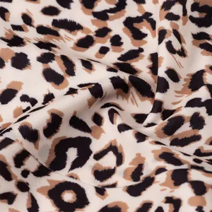 Détail de tissu en soie glacée à imprimé léopard avec texture lisse et design animalier.