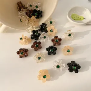 Primo piano dettaglio del set di mini mollette per capelli floreali con strass brillanti.
