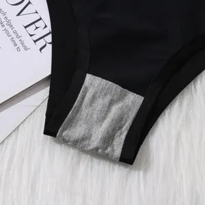 Primo piano dettaglio di slip donna nero senza cuciture con tassello in cotone traspirante.