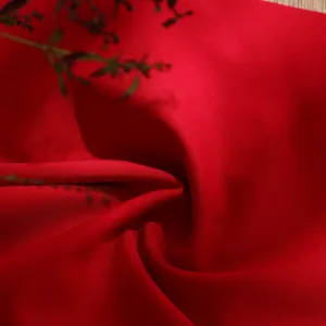 Red fabric detail close up showing smooth texture and fine weaving quality for apparel crafting.