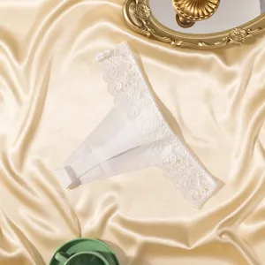 Vue détaillée du string blanc en dentelle taille basse avec broderie florale exquise.