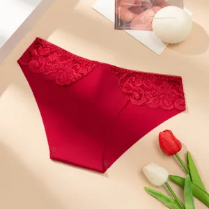 Women's sexy low-waist red seamless panties featuring delicate floral lace trim and soft fabric.