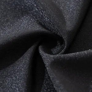 Detalle de tela elástica negra brillante de seda de hielo, textura suave y material transpirable.
