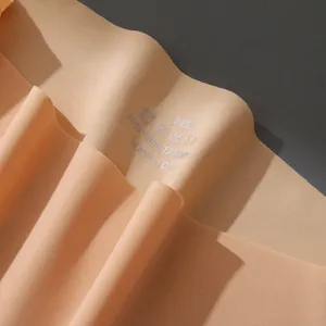 Detailed view of seamless nude underwear fabric showing fabric texture and printed wash label info.