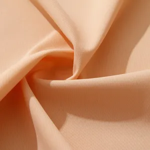 Detailed close-up view of smooth peach fabric texture, seamless underwear material macro shot