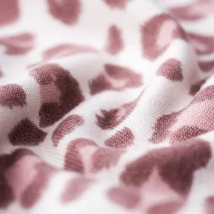 Close-up of pink and white leopard print fabric showing fine knit texture and soft folds.