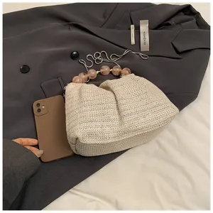 Beige strohgewebte Handtasche für Damen mit stilvollem Perlen-Griff und gerafftem Design.