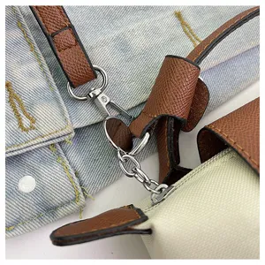 Detail der Mini-Nylon-Umhängetasche mit braunem Lederbesatz und silbernen Beschlägen.