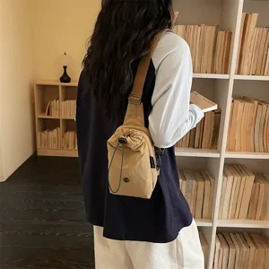 Detailansicht khakifarbene Segeltuch Umhängetasche, lässige Brusttasche mit Kordelzug.