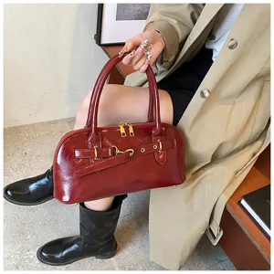 Detailansicht der roten Damen Handtasche aus Leder mit goldenen Beschlägen und Griffen.