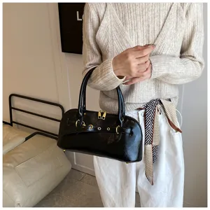 Schwarze Umhängetasche aus Lackleder mit Metallschnalle und Reißverschluss für Damen.