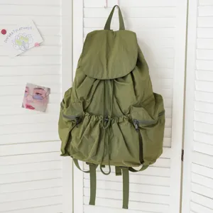 Detailansicht des waschgrünen Stoffrucksacks mit praktischem Kordelzug und Taschen.