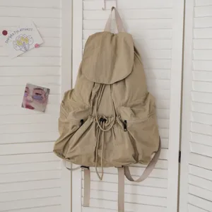 Nahaufnahme eines lässigen khakifarbenen Rucksacks aus Waschlappen mit Kordelzug und Klappe.