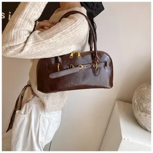 Detailaufnahme einer eleganten dunkelroten Leder Schultertasche mit goldener Hardware.