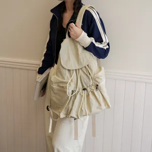 Detailansicht des beigen, gewaschenen Stoffrucksacks mit Kordelzug und vielen Taschen.