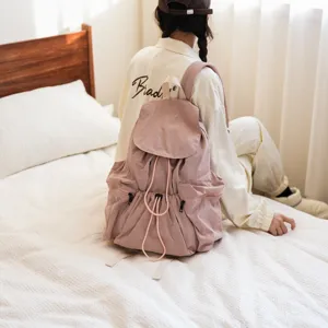 Detailansicht des lässigen Kordelzug-Rucksacks aus Washed-Stoff in sanftem Altrosa im Alltag.