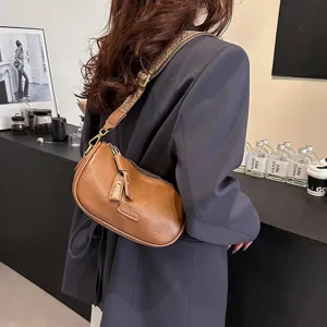 Detailansicht der Damen Retro braunen Hobo Schultertasche mit breitem Gurt und Design.