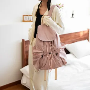Detailansicht eines stylischen rosa Kordelzug-Rucksacks aus Waschlappenstoff im Schlafzimmer.