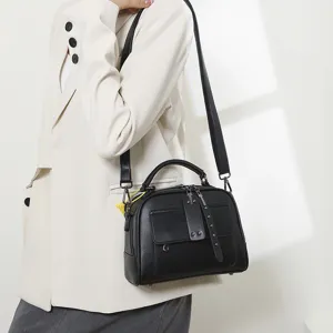 Schwarze Leder Umhängetasche für Damen mit Griff, Klappentasche und schicken Metalldetails.