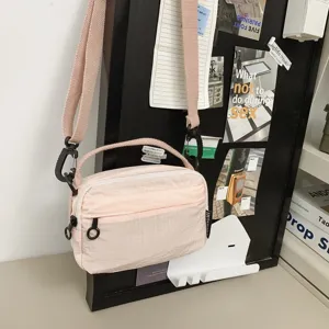 Details der leichten Nylon-Umhängetasche in Rosa mit praktischem Schultergurt und Reißverschluss.