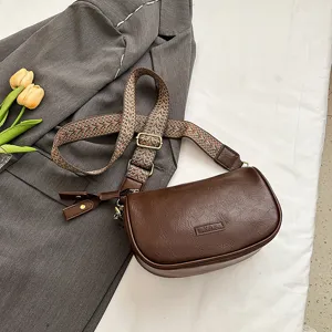 Retro braune Ledertasche mit breitem Ethno-Gurt, schicke lässige Schultertasche Detail.