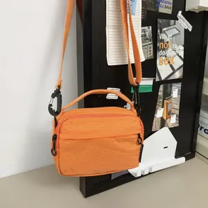 Detailaufnahme der hellorangefarbenen Nylon Umhängetasche mit robustem Reißverschluss.