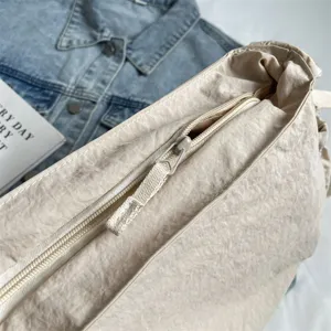 Detailansicht der lässigen beigen Nylon Umhängetasche mit schicker Knittertextur und Reißverschluss.