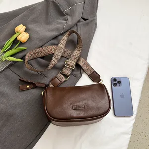 Detailaufnahme der braunen Damen Umhängetasche aus Leder mit gemustertem Gurt und feinem Design.