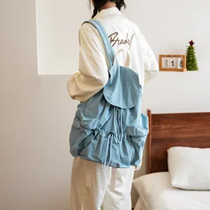 Nahaufnahme des hellblauen Kordelzug-Rucksacks mit weichem Stoff und praktischen Taschen.