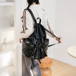 Detailansicht des schwarzen Kordelzug-Rucksacks mit glänzendem Stoff und großem Fassungsvermögen.